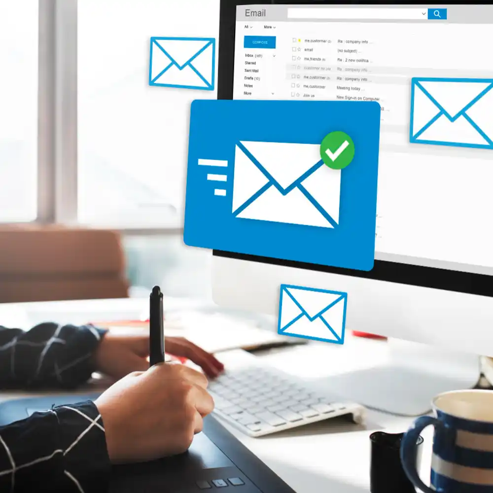 A person works on email marketing with floating email icons surrounding the screen one has a green checkmark conveying productivity